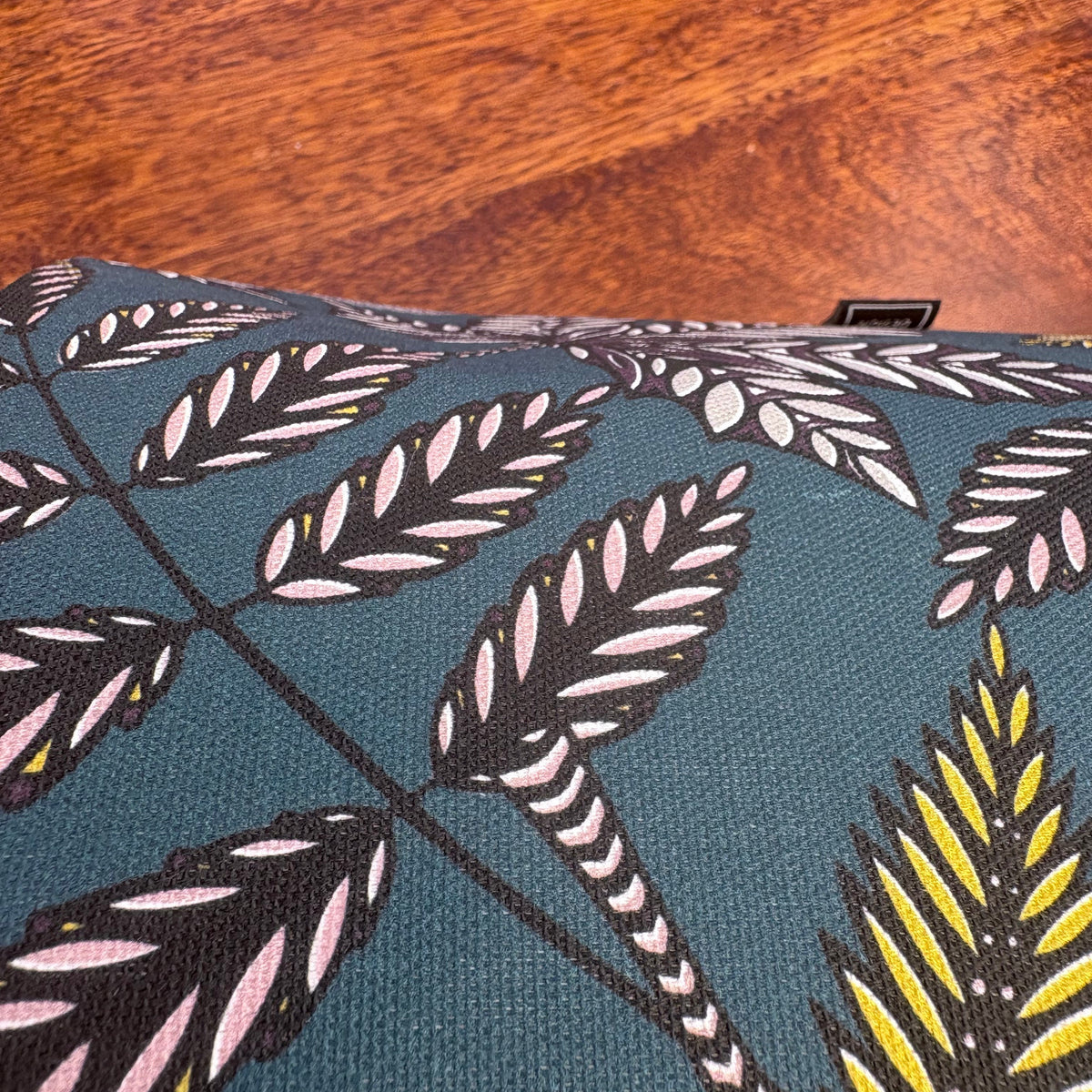 close up of a teal lampshade showing a small dent on it.