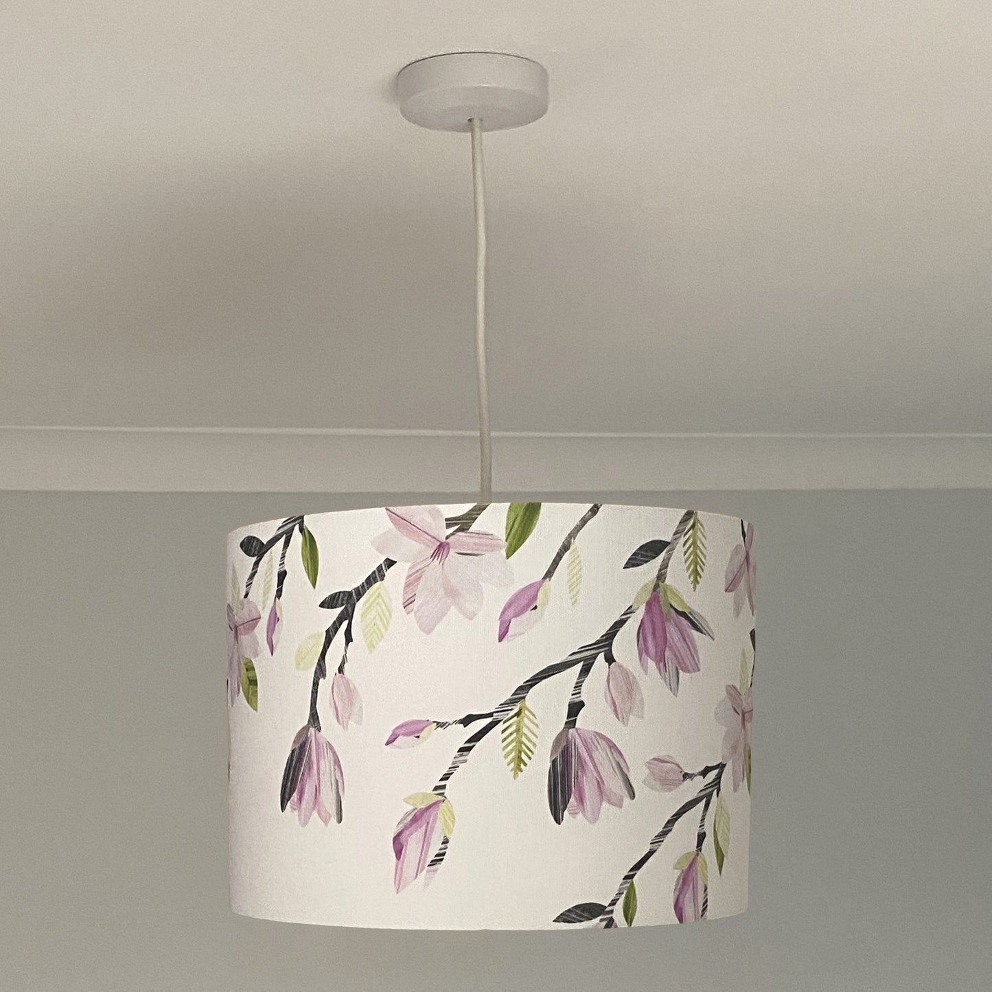 A medium magnolia pendant is hanging down from the ceiling.
