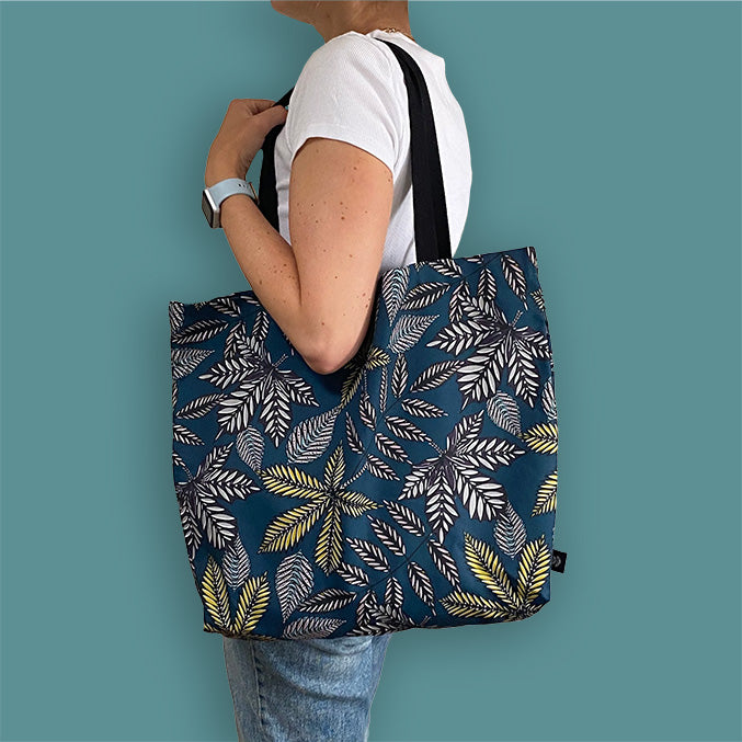 Teal Forest Floor Tote Bag worn over a ladies shoulder.