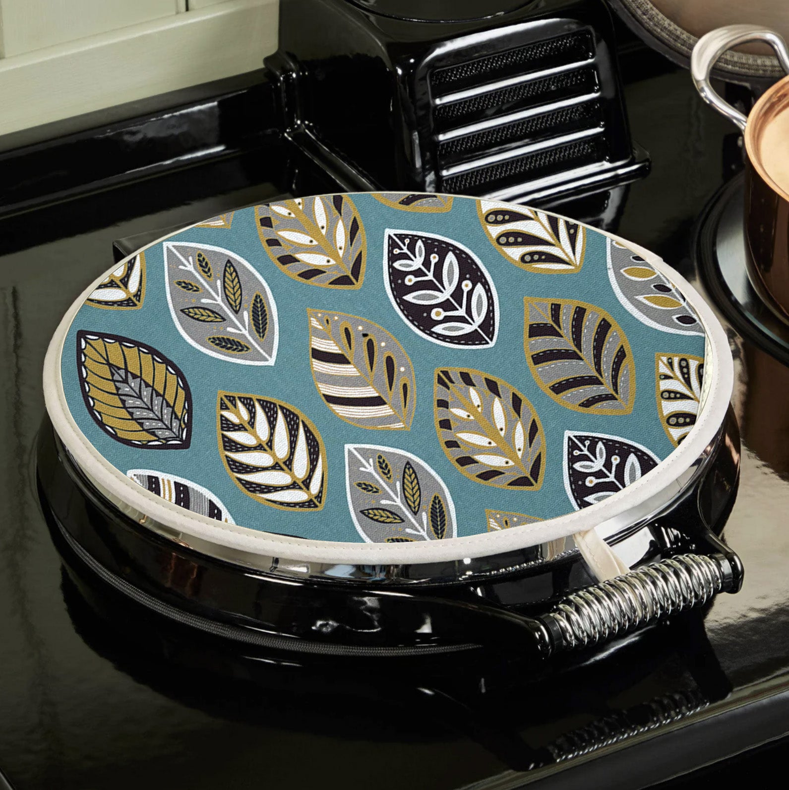 A Blue Beech leaf Aga topper has been placed on a black AGA.  you can see how the hanging loop hooks onto the top of the hob.