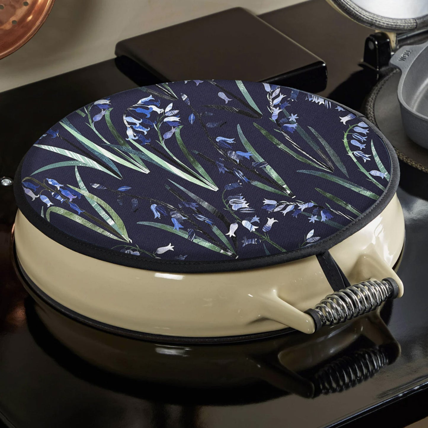 A Bluebell Aga topper has been placed on a black and cream AGA.  You can see how the hanging loop hooks onto the top of the hob.