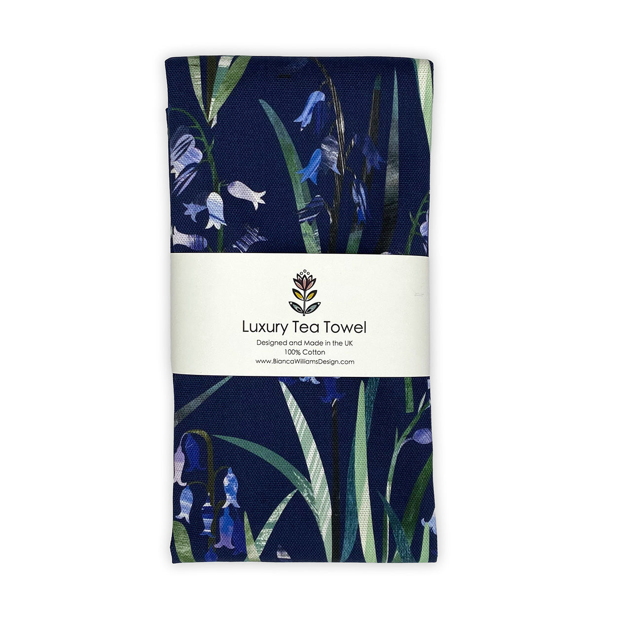 A Navy Blue Bluebell Tea Towel featuring hand collaged Bluebell motifs with the pretty little bluebell flowers and green leaves has been packaged and placed on a plain white background.