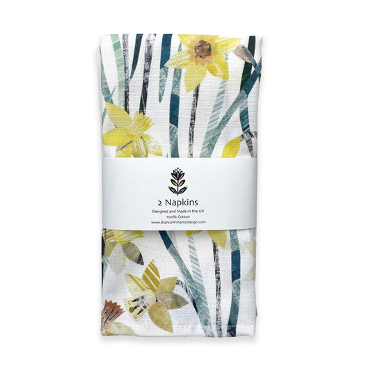 A pair of Daffodil Napkins packaged in a branded belly band and placed on a white background.