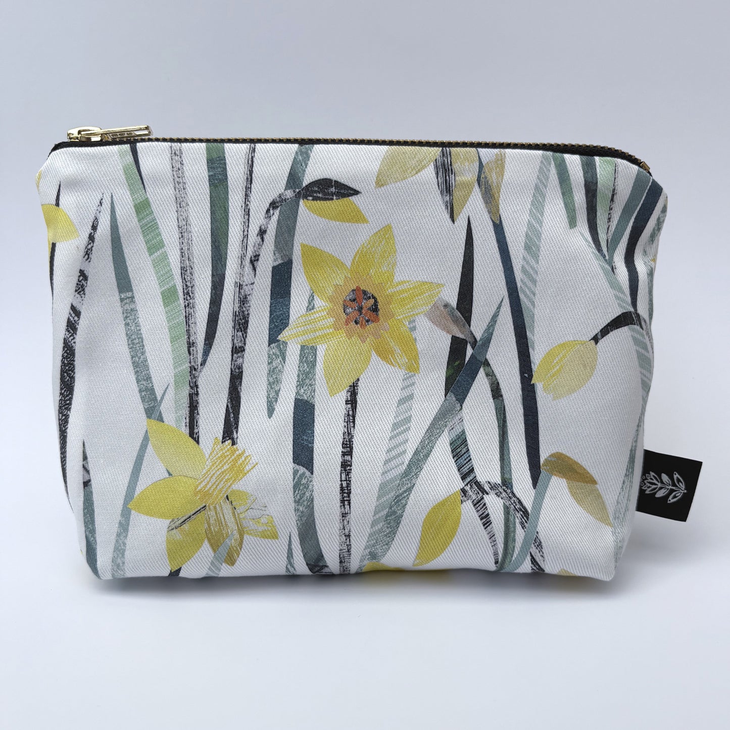 A Daffodil make up bag has been placed on a white backdrop.