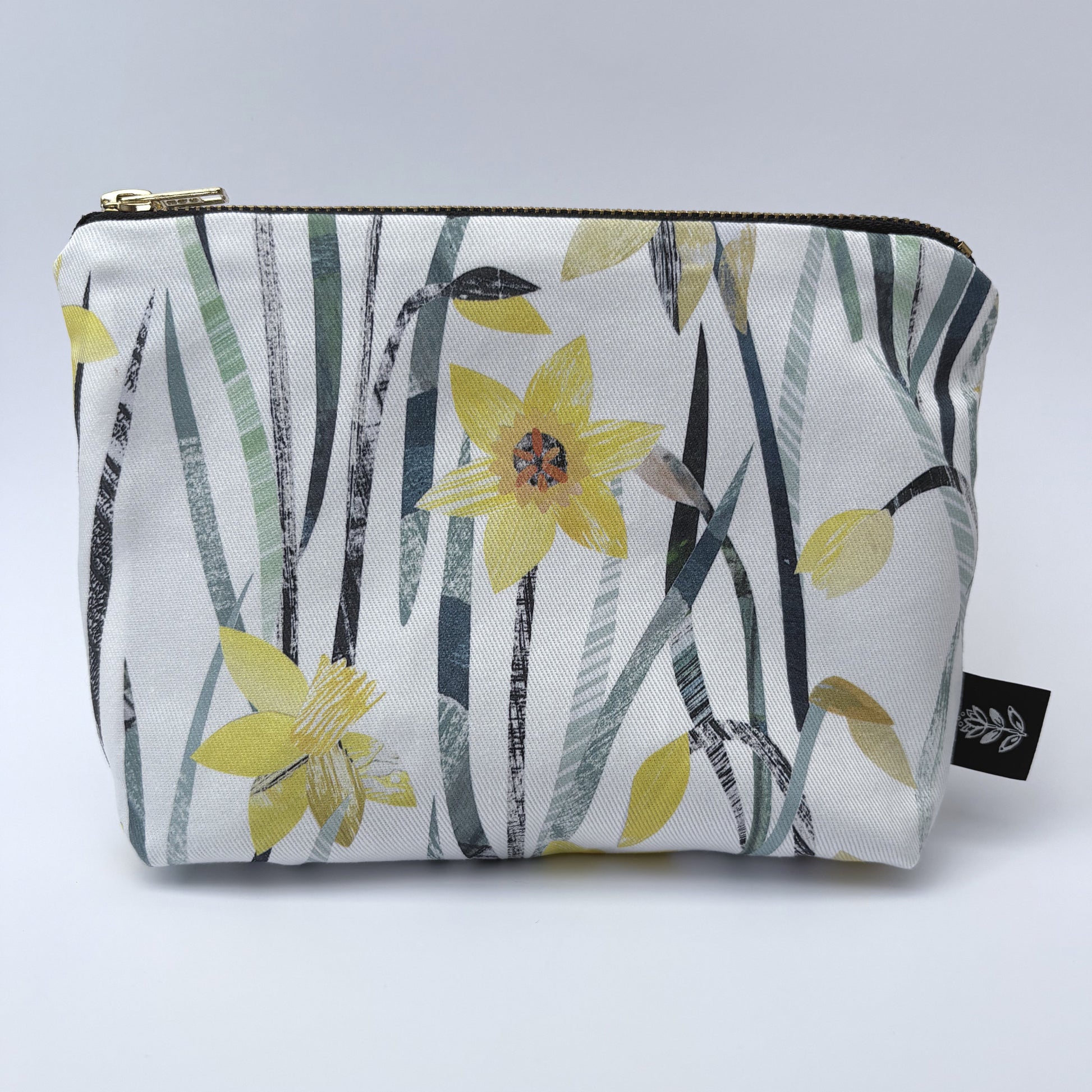 A Daffodil make up bag has been placed on a white backdrop.