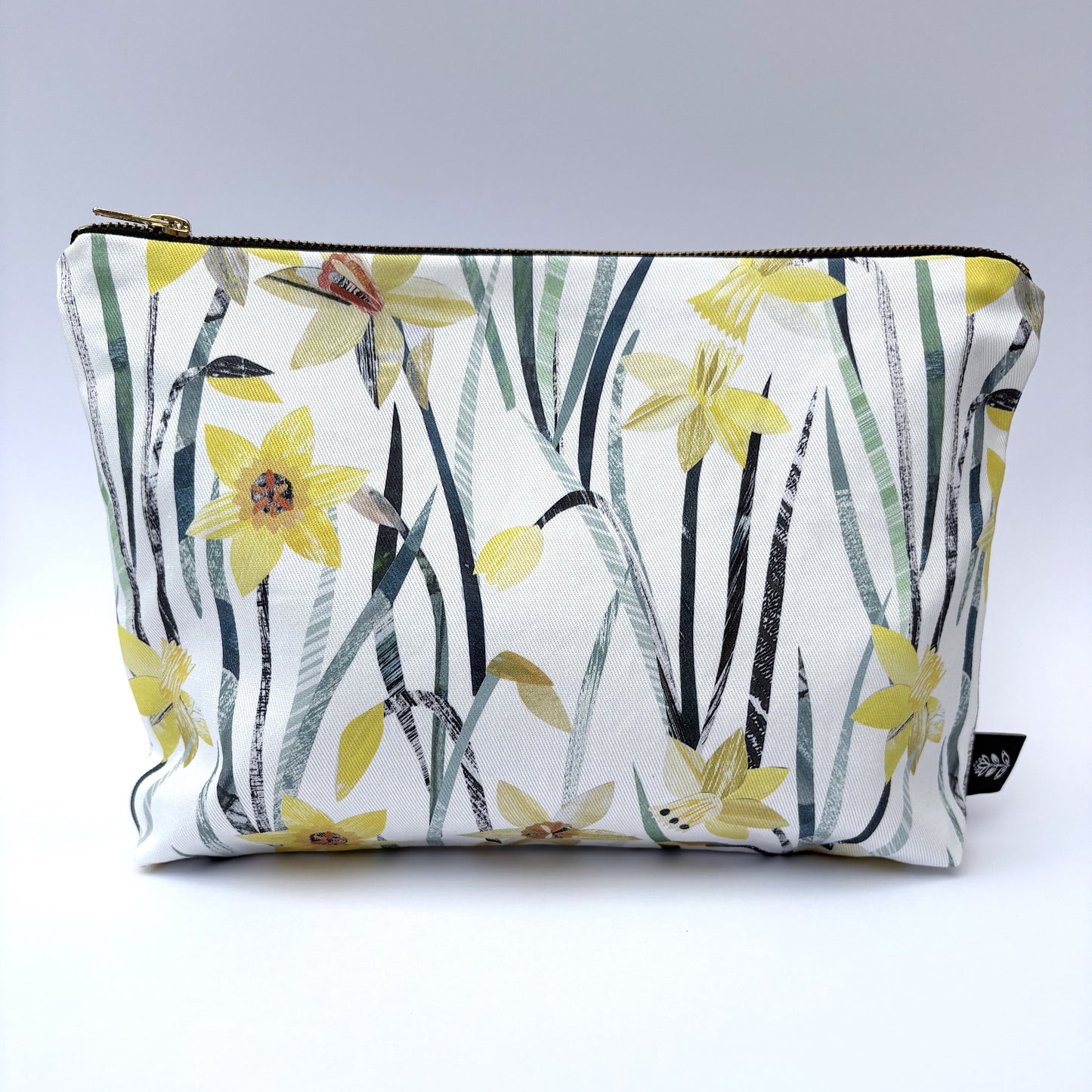 A Daffodil wash bag featuring the pretty yellow and green flowers has been placed on a white background.
