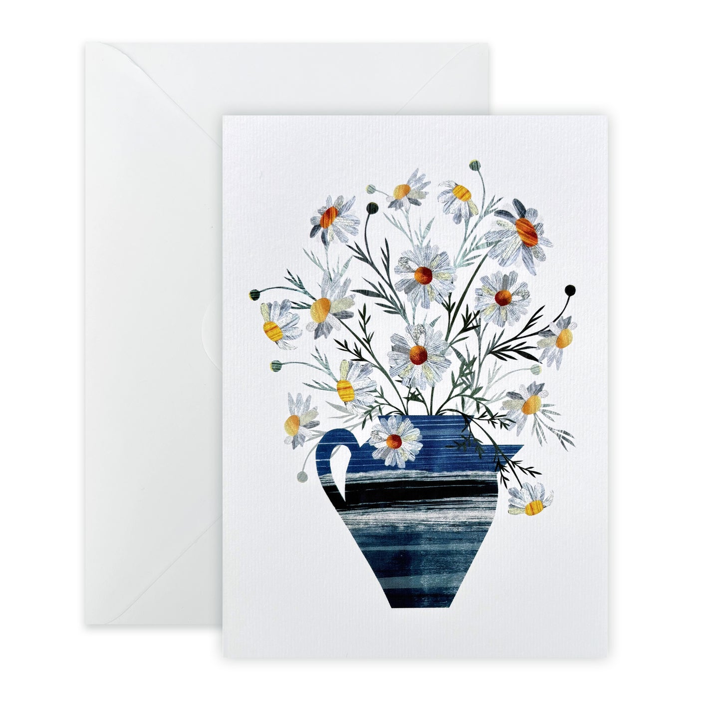 Delicate white Daisies in a blue Vase one a lightly textured white card has been placed on a white background with a white envelope.