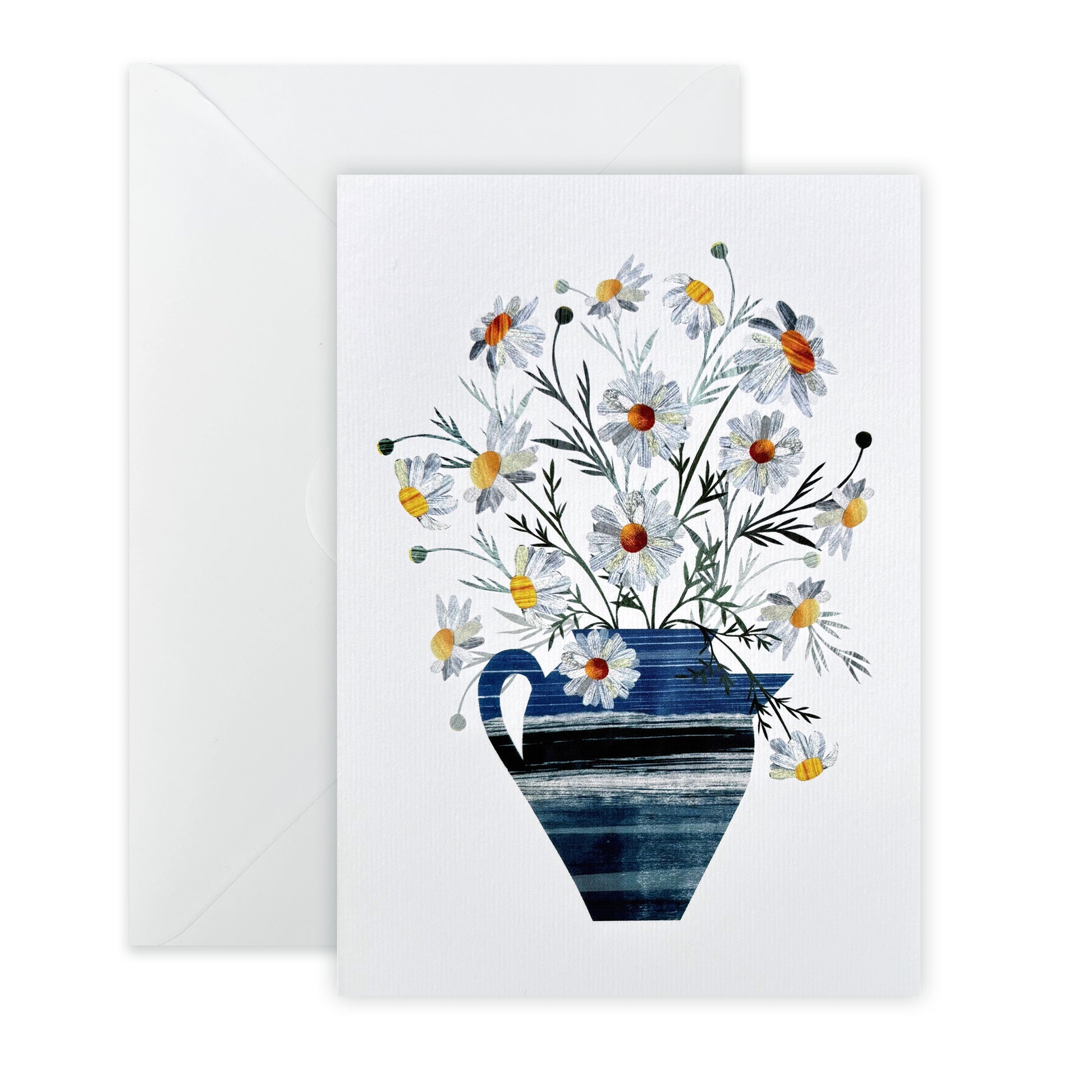 Delicate white Daisies in a blue Vase one a lightly textured white card has been placed on a white background with a white envelope.