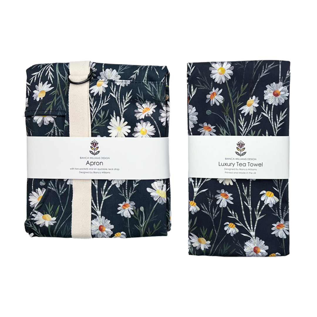 A packaged Daisy Apron and matching Tea Towel have been placed on a plain white background.