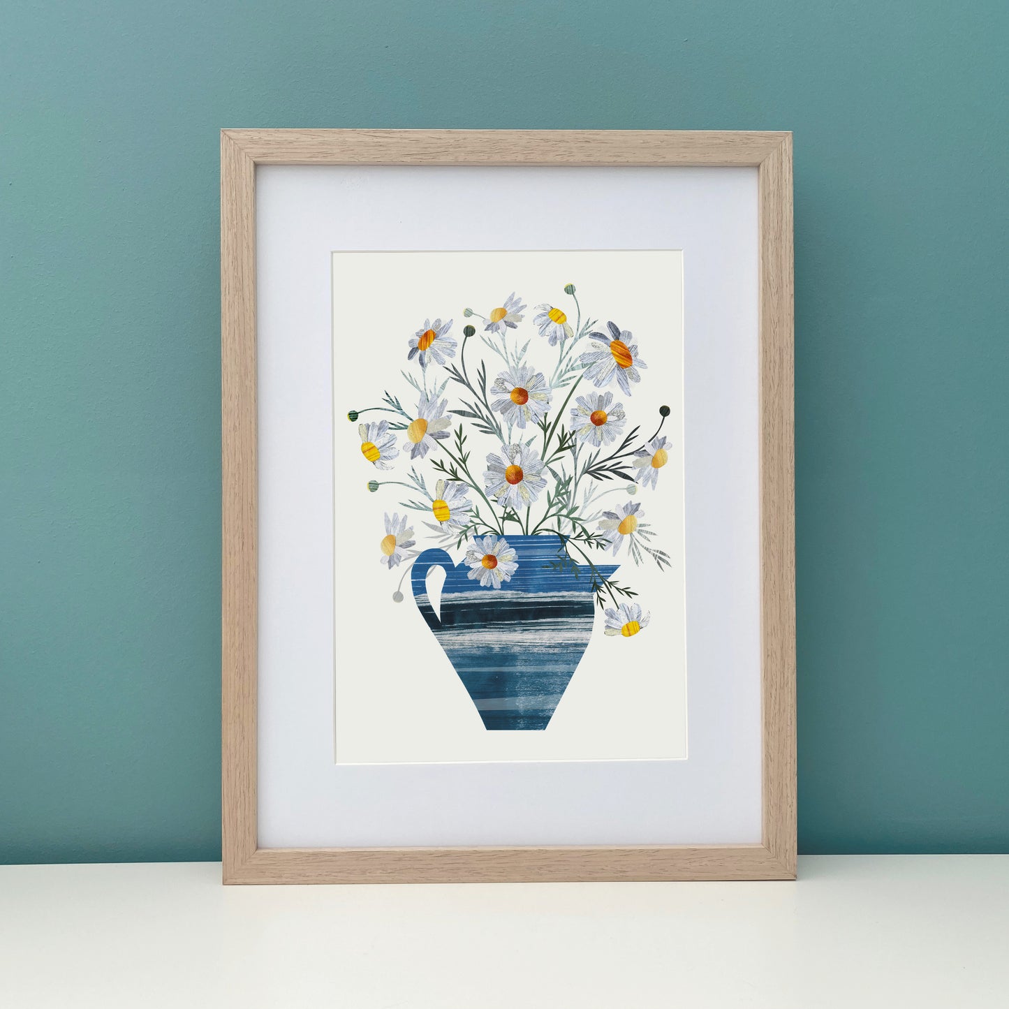 Framed Daisy artwork against a teal wall.
