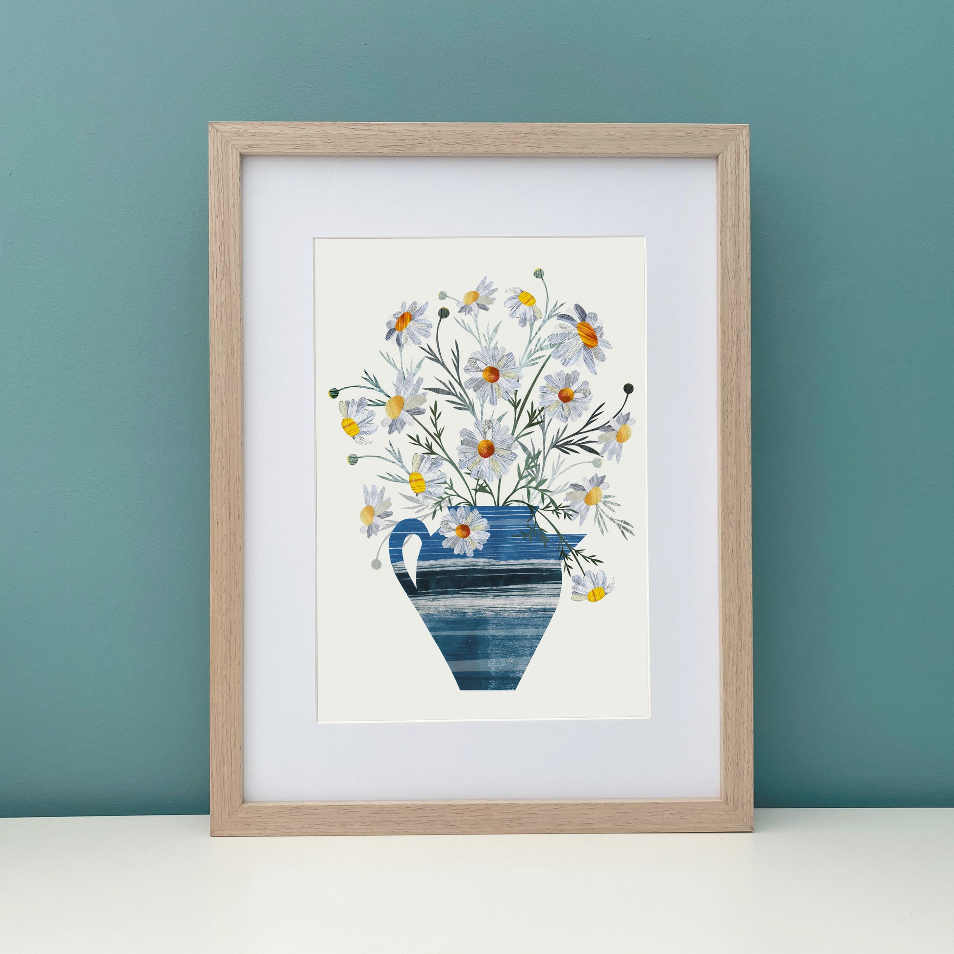 Framed Daisy artwork against a teal wall.