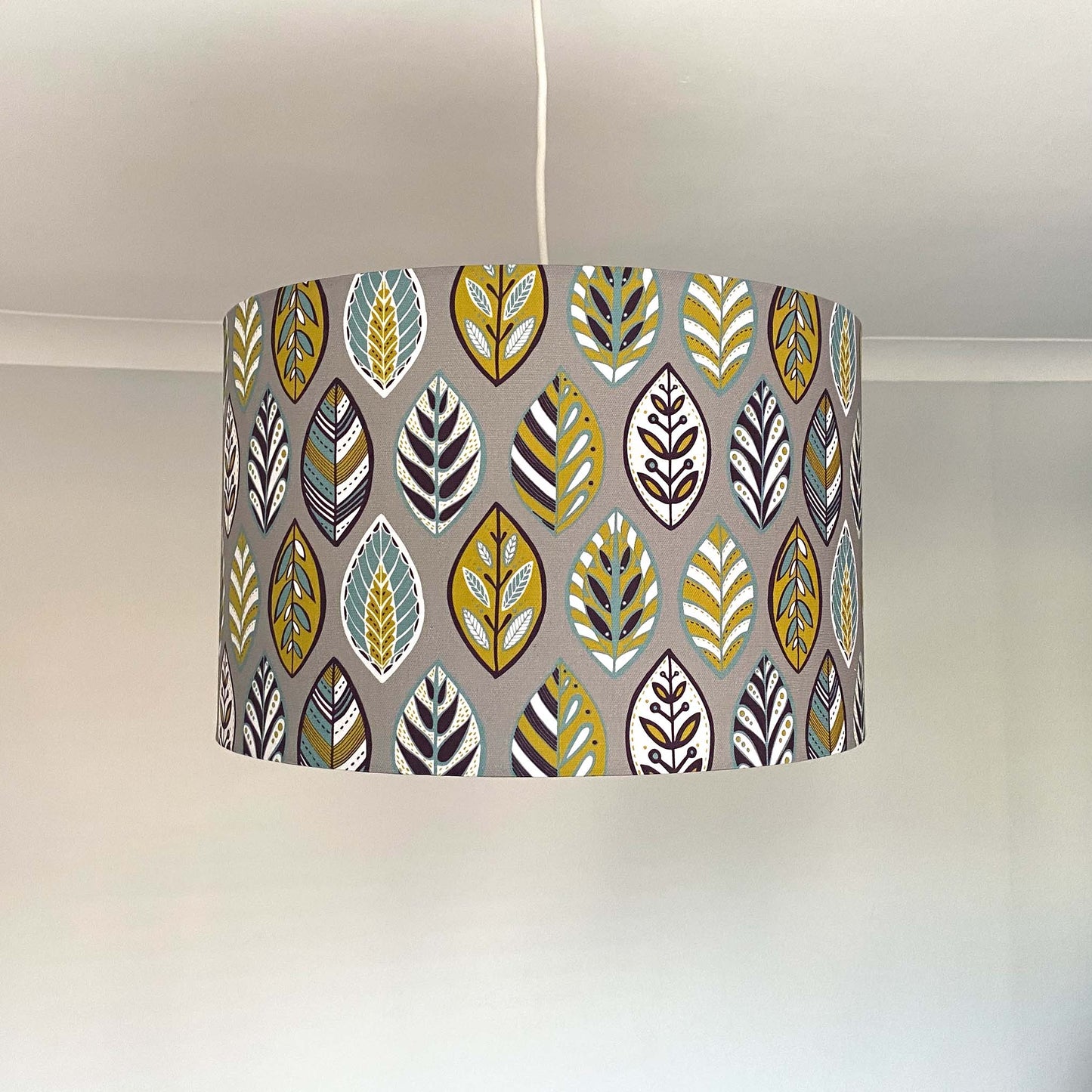 Large Grey Oak leaf Lampshade with a ceiling pendant fitting.  This pattern features Blue, Yellow, White and Aubergine leaf Pattern in a Skandinavian style on a Grey background.