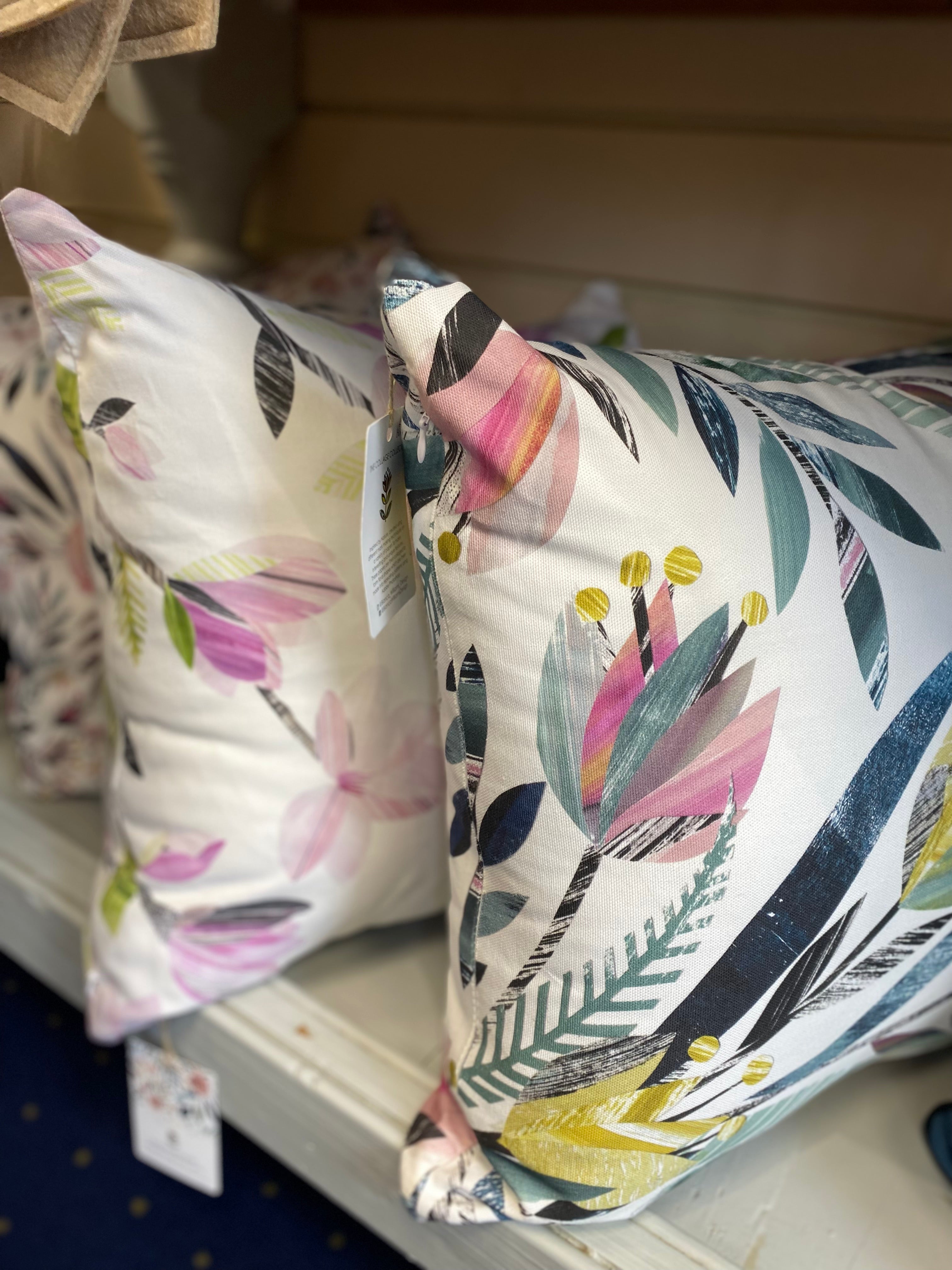 Tulip and Magnolia Cushions placed side by side on a shelf.