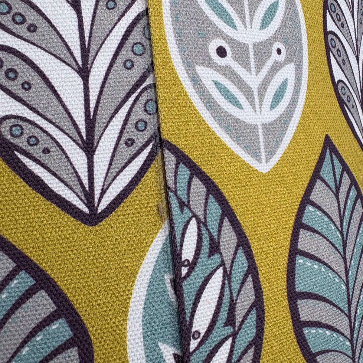 Patterned fabric with leaf designs on a yellow background
