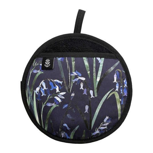 Bluebells Pot Holder featuring the pretty Blue flowers on a Navy Blue background.  The pot grab has a black hanging loop and a brand label sewn onto hand opening.  It has been placed a white background.