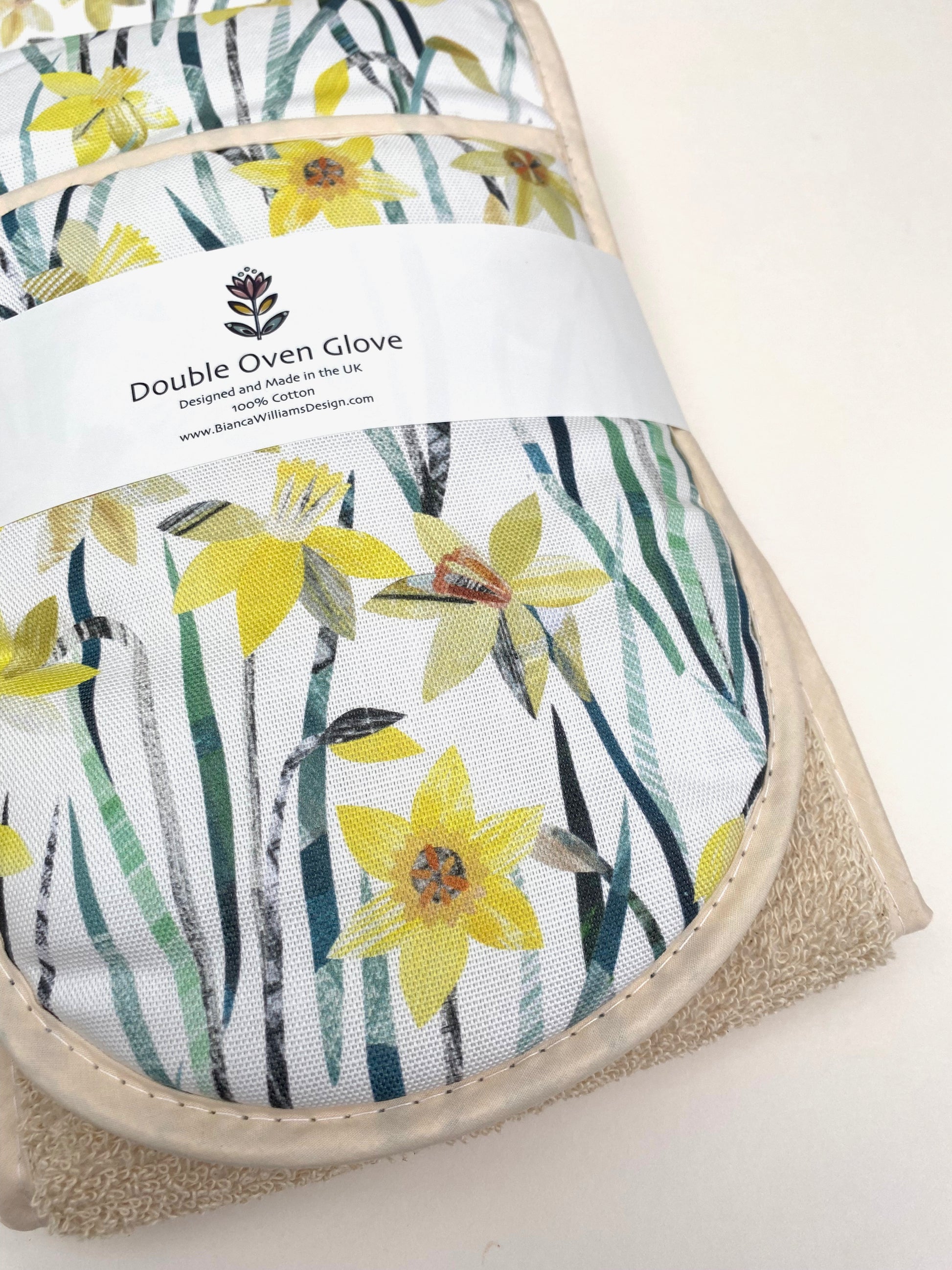 Close up of the daffodil Ovengloves, shows some of the lovely textured details of the pattern and Green and yellow colours as well as the lightly textured fabric.
