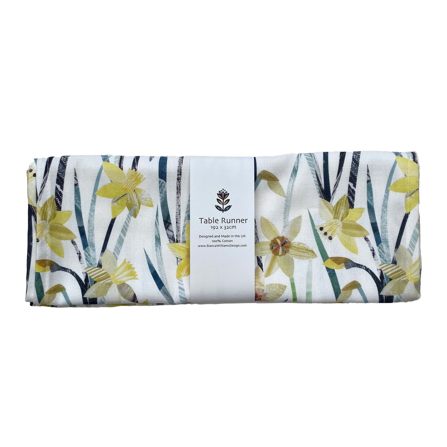 A folded and packaged Daffodil Table Runner, which has been packaged in a branded white belly band and place on a white background.