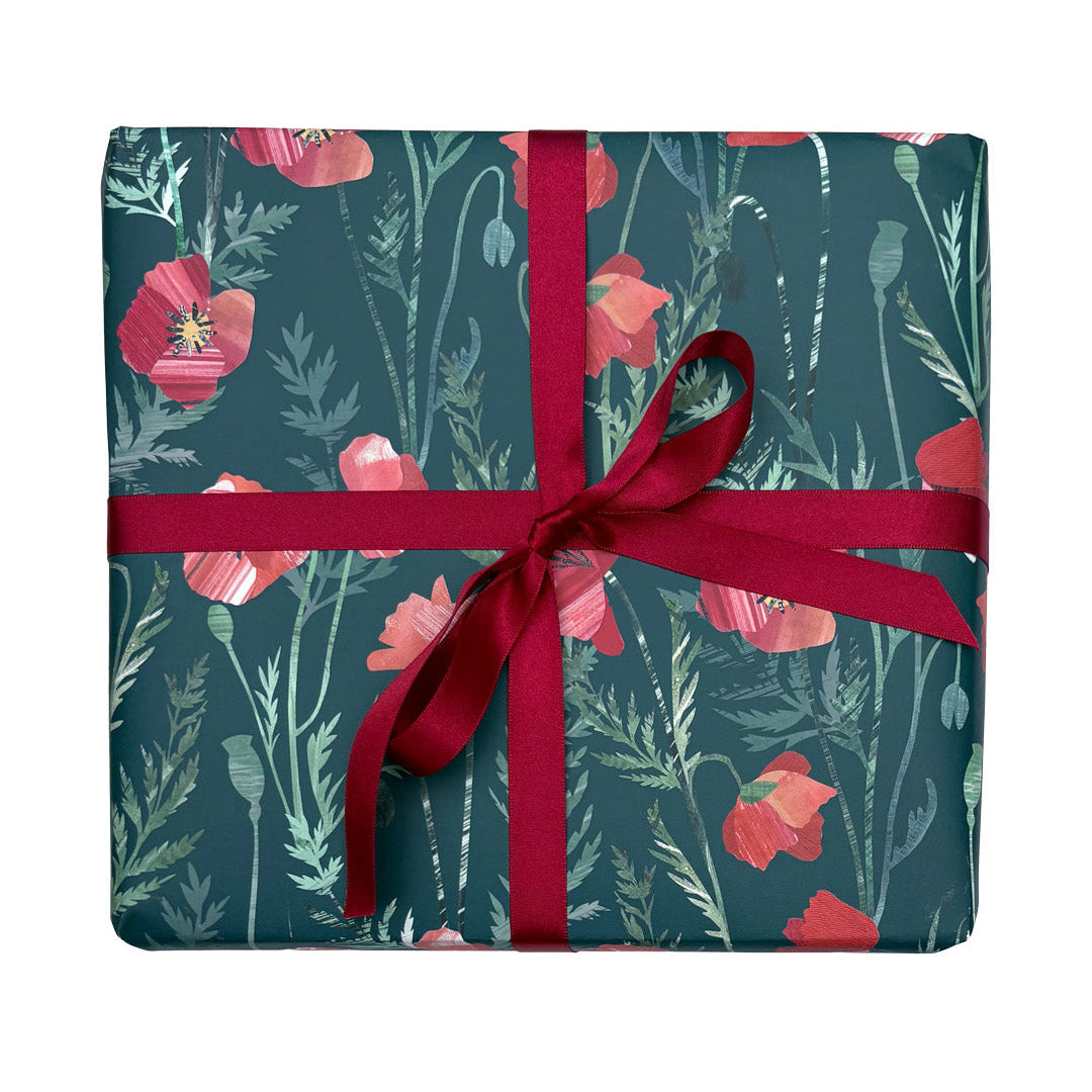 A present has been wrapped in Poppy Gift Wrap and has been tied with a coordinating Red satin ribbon and placed on a plain white background.