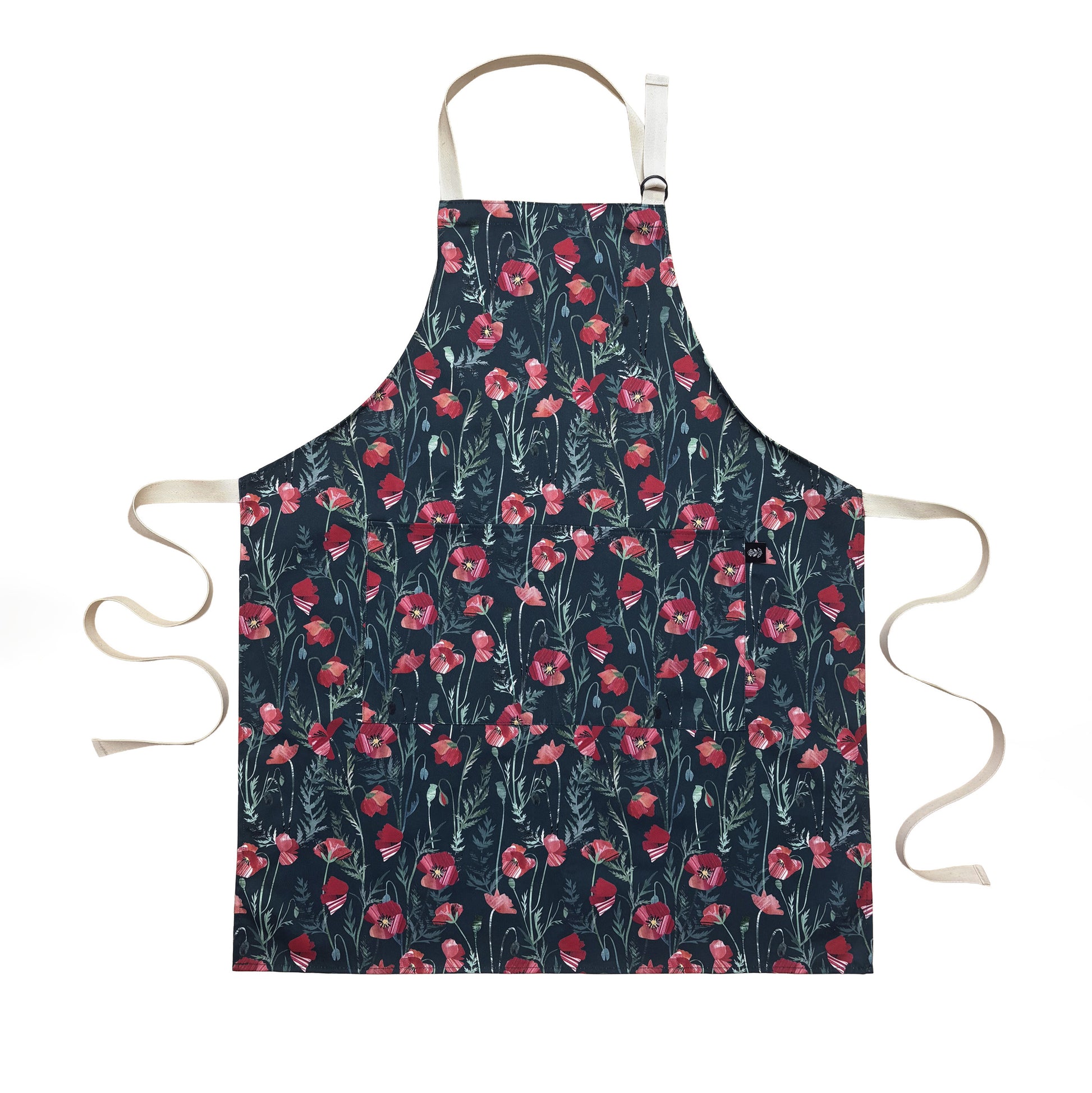 A Poppy Apron has been laid flat on a white background.  It is covered with the red flowers with green leaves on a dark green background.  It has Ecru cotton webbing ties and an adjustable neck strap.