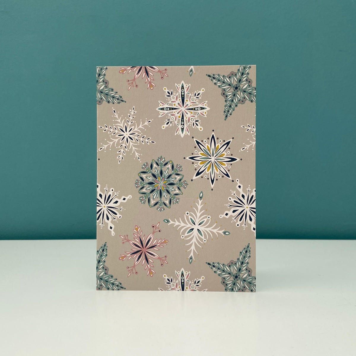 A grey Snowflake card has been placed on a white shelf.