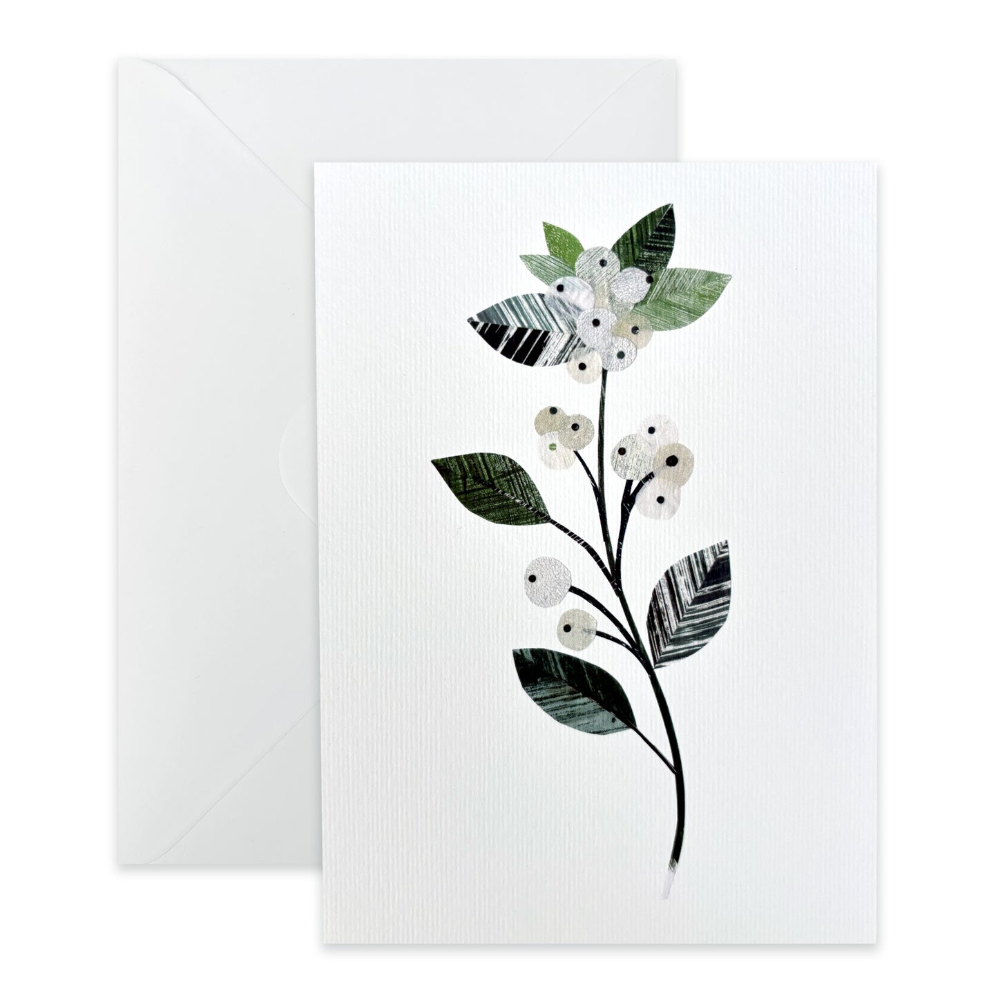 Greeting card with a winter floral design featuring a Snowberry sprig of delicate white berries with textured green leaves on a white background with a white envelope.