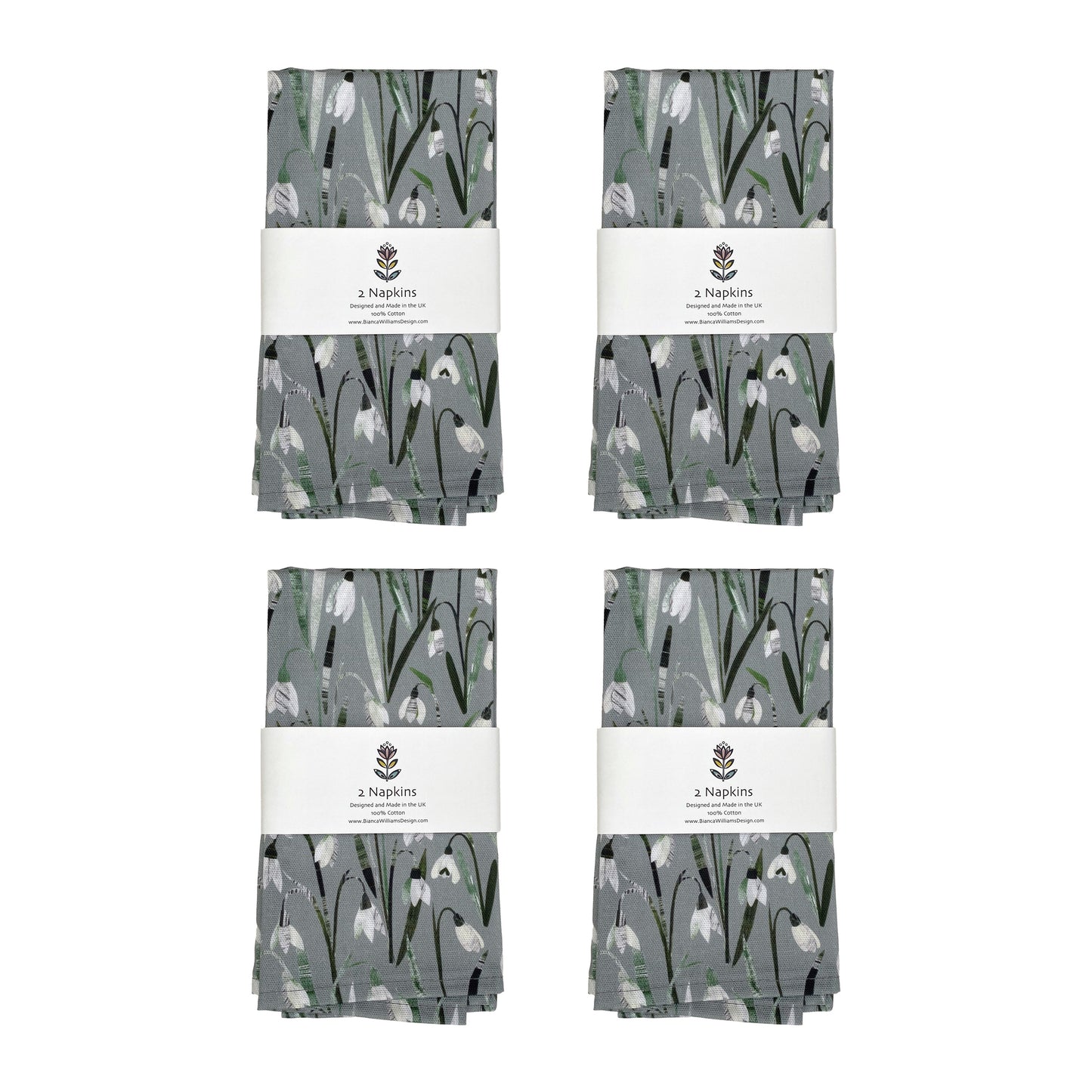 Four pairs of Snowdrops Napkins packaged in a white branded belly band and placed on a plain white background.