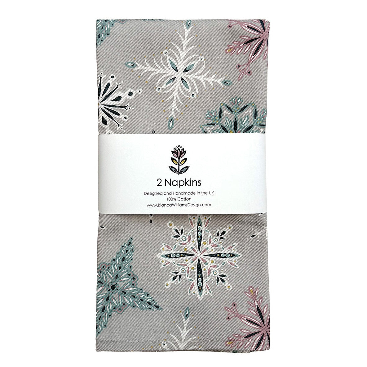 A set of two napkins featuring a hand drawn snowflake pattern on a light grey background have been packaged in a branded belly band and placed on a white background.