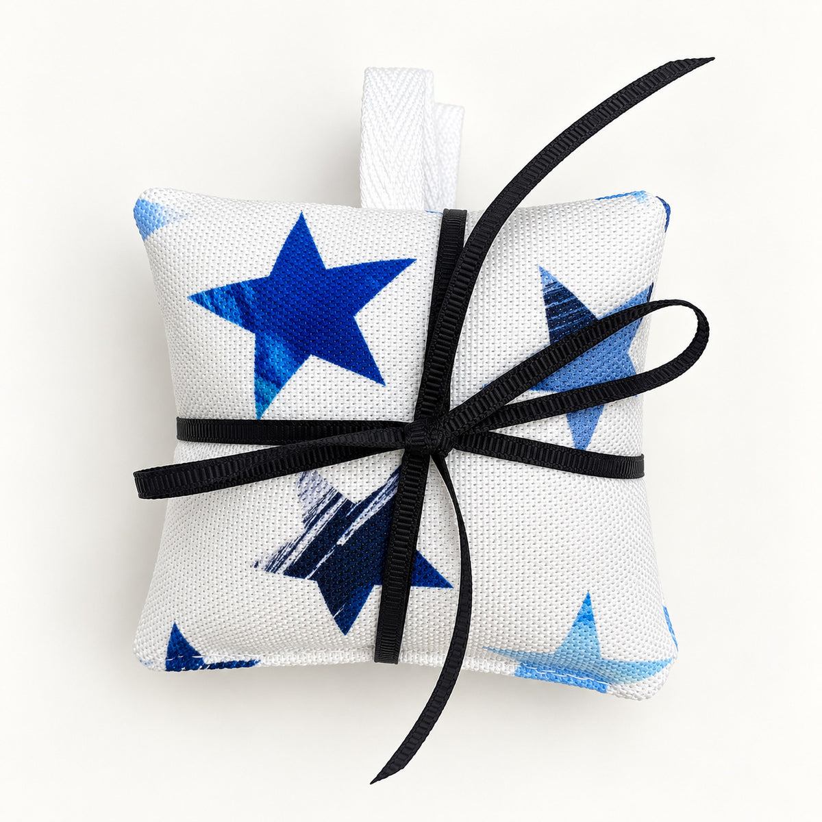 A pack of three lavender bags have been tied in a bow and placed on a pain white background.  They feature a blue star pattern on a white background.