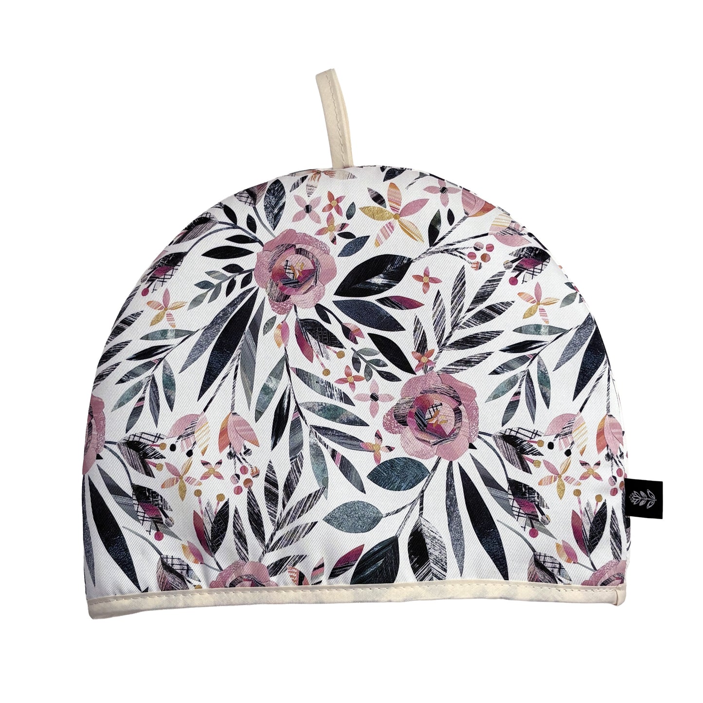 Summer Floral Tea cosy with pink roses and green leaves has been placed on a white background. A Brand label can be seen sewn into the seam and a cotton hanging tag out of the top.