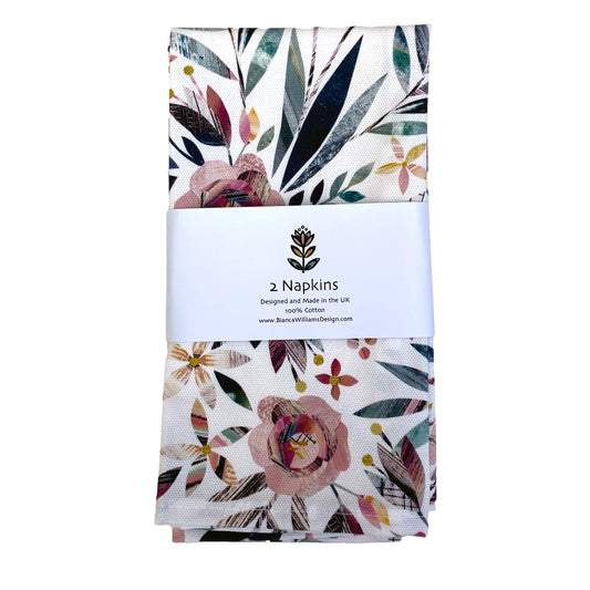 A pair of Summer Floral napkins packaged in a branded belly band and placed on a white background.