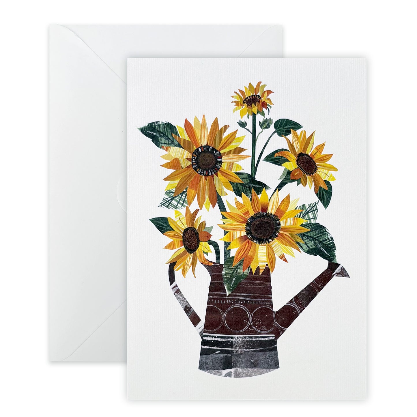 A white card with an image of yellow and Orange sunflowers with green leaves in a watering can has been placed on a white background with a plain white envelope.