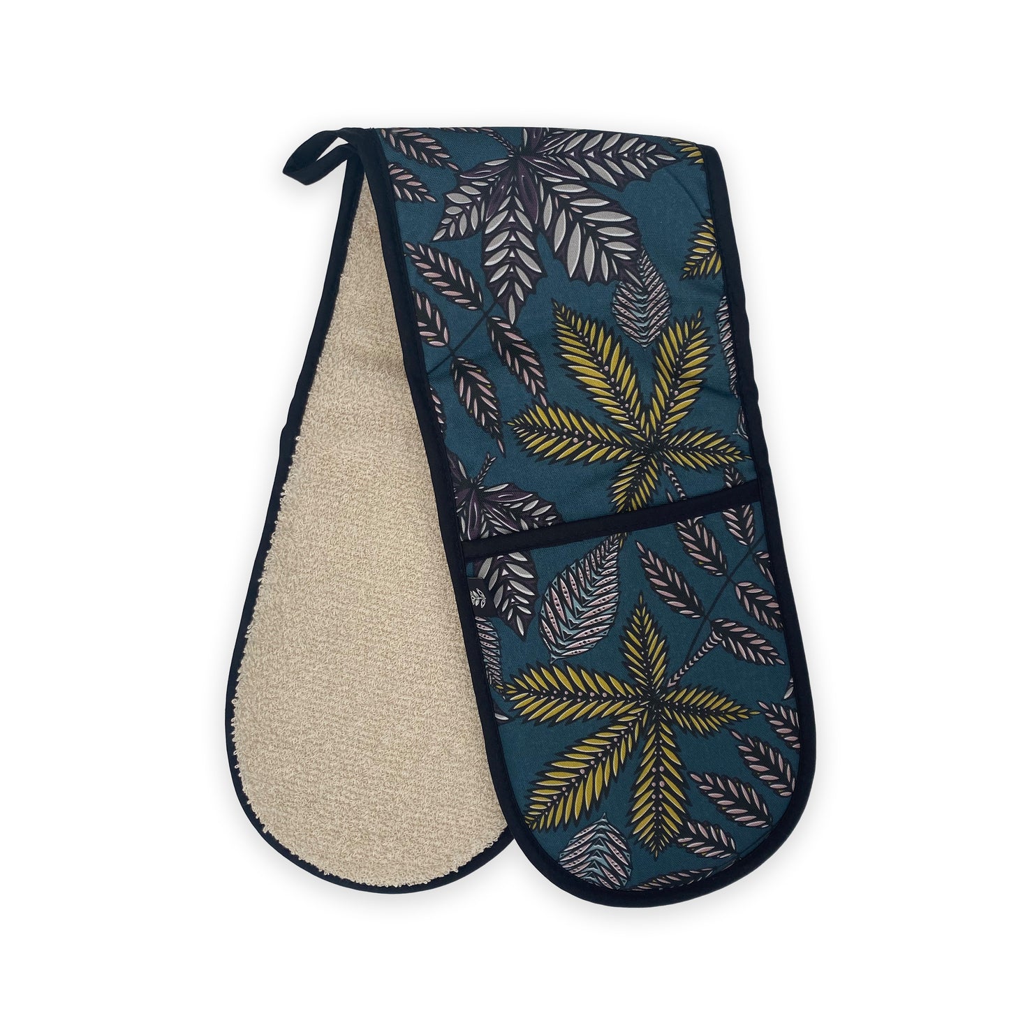 These Teal Forest Floor Oven Gloves have been folded in half and placed at an angle, so that the Skandi style leaf pattern can be seen on the front of the Oven Gloves and the Cotton Ecru towelling can be seen on the reverse.  There is also a black hanging loop.