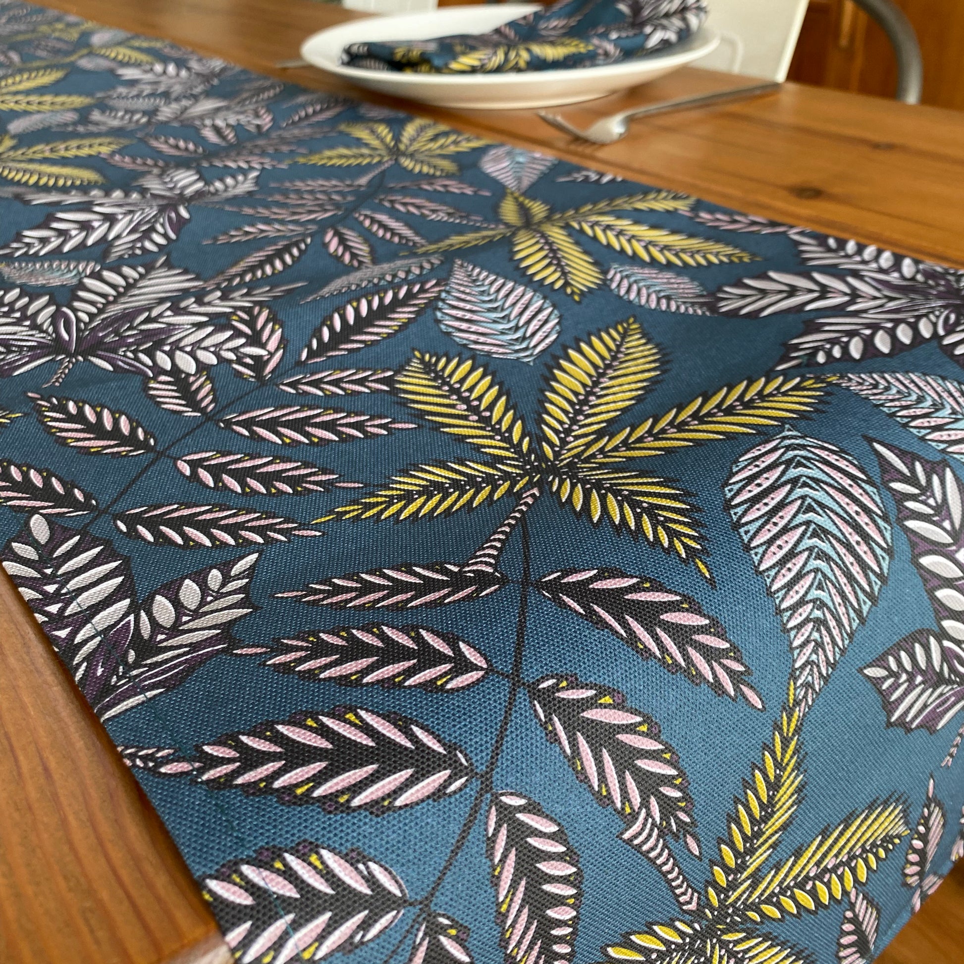 Close up of the Teal Forest Floor table Runner, showing the lightly texture cotton fabric.