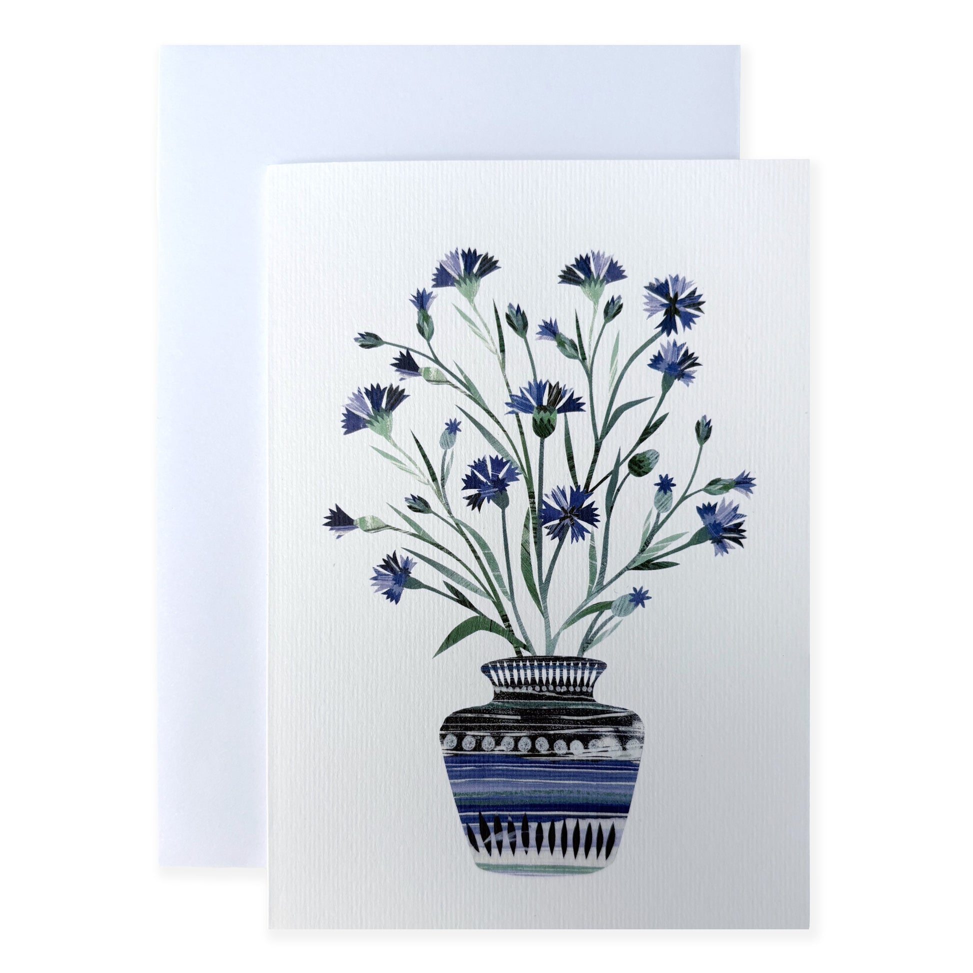 A Greeting card with a Vase of Cornflowers on it has been placed on a white surface with a white envelope.