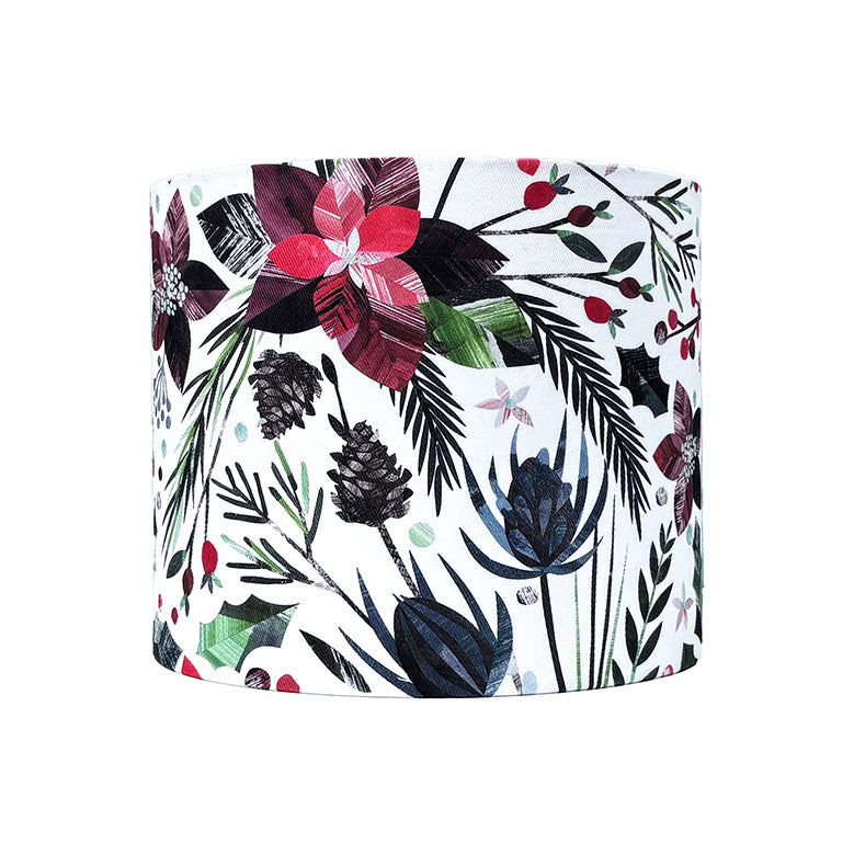 A small sized Winter Floral Lampshade featuring textured red poinsettia flowers, green Holly, berries and fir has been placed on a white background.
