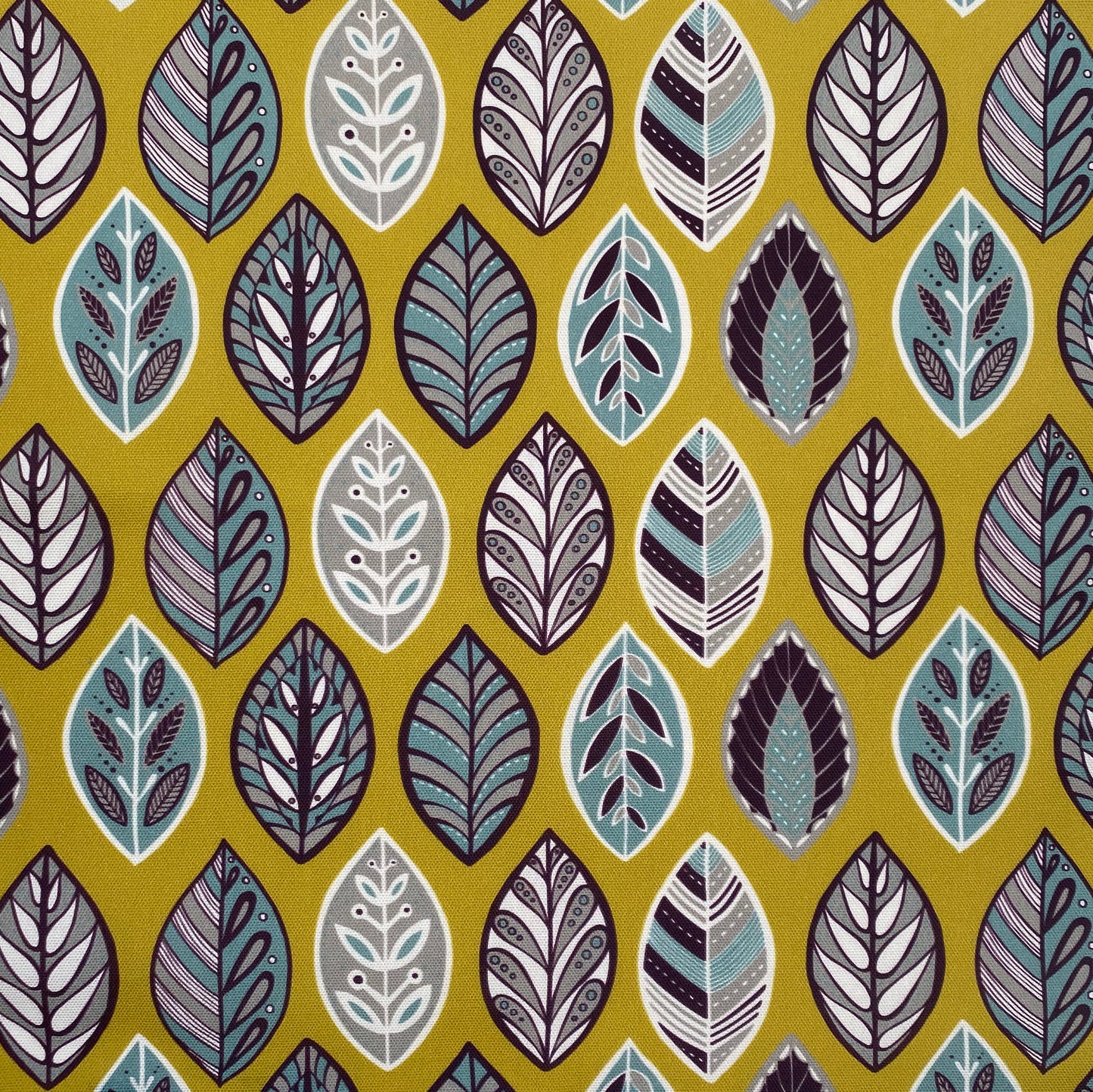 Yellow Beech Leaf fabric features simple leaf motifs in white, blue, aubergine and grey on a yellow background.