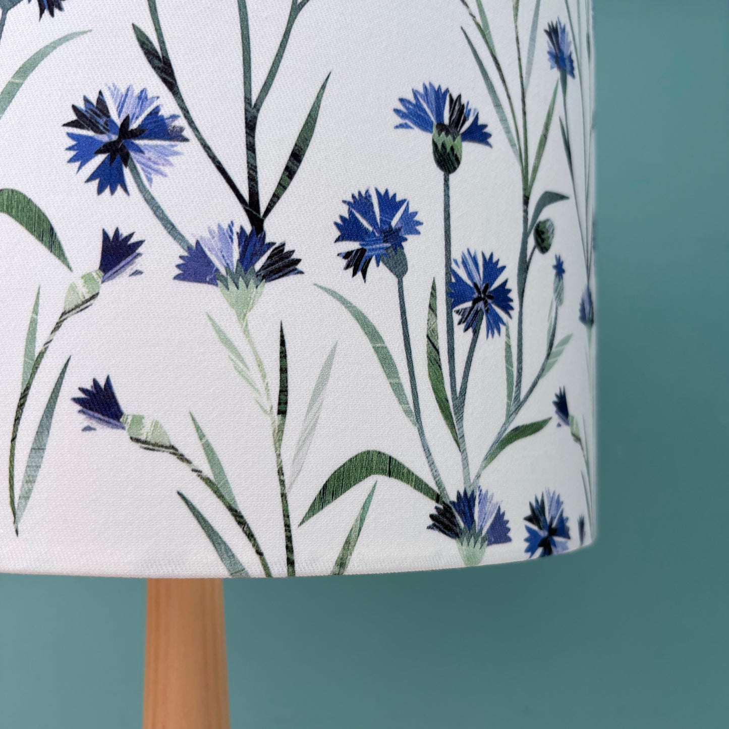 Close up of a Lampshade with blue floral design on a white background.