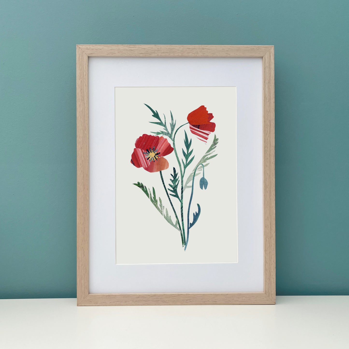 Framed artwork of a Red Poppy Flower on a teal wall.