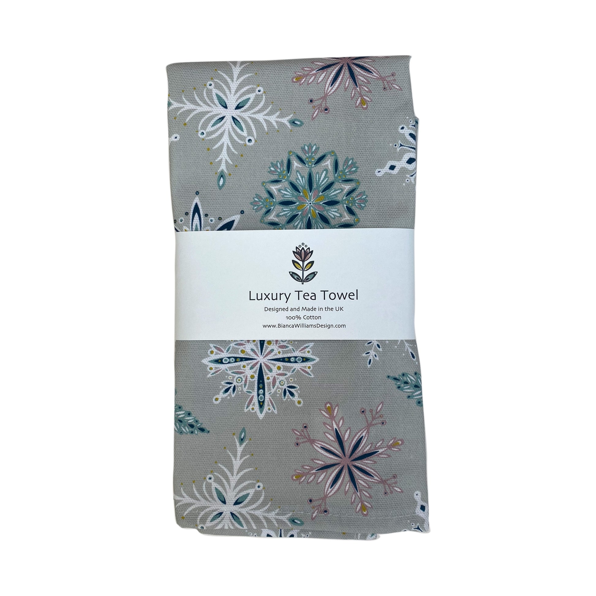 A Grey Snowflake Tea Towel has been packaged in a branded belly band and placed on a white background.