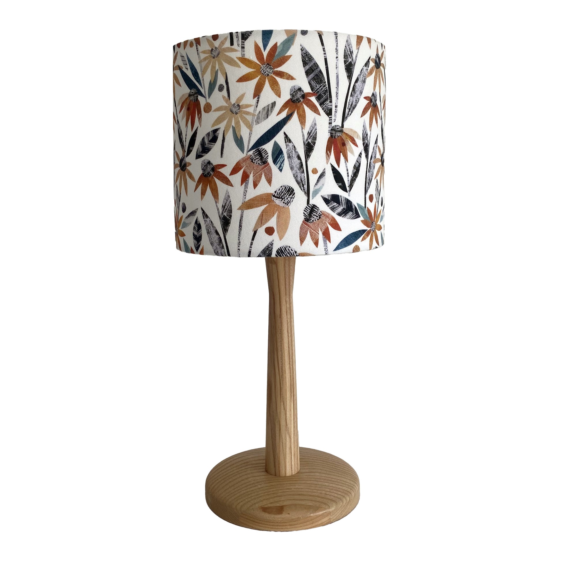 Small Autumn floral lampshade featuring pretty orange rudbeckia flowers with green and dark grey leaves on a white background.  It has a wooden lamp base.